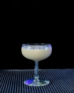 The P.S. I Love You cocktail on a home bar top with an all black background