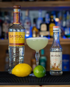 The Pisco Sour on a home bar top surrounded by its ingredients