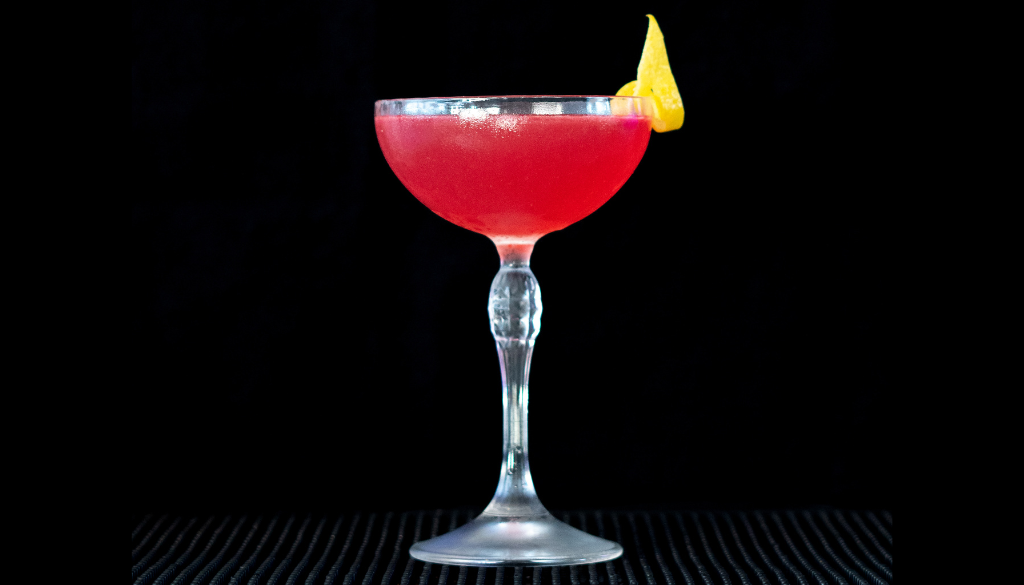 The Cosmopolitan cocktail on a home bar top with an all black background