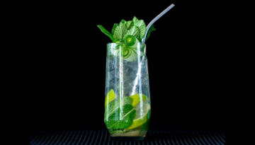 The cucumber mojito cocktail on a home bar top with an all black background