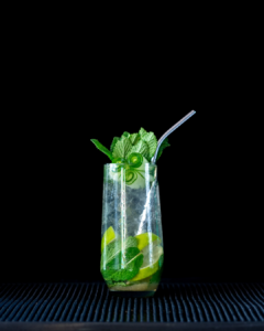 The cucumber mojito cocktail on a home bar top with an all black background