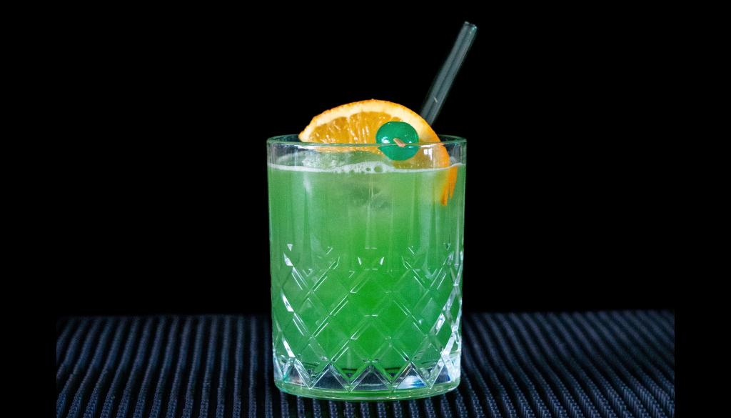 The Drunken Leprechaun cocktail on a home bar top with an all black background
