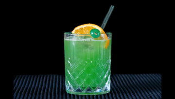 The Drunken Leprechaun cocktail on a home bar top with an all black background