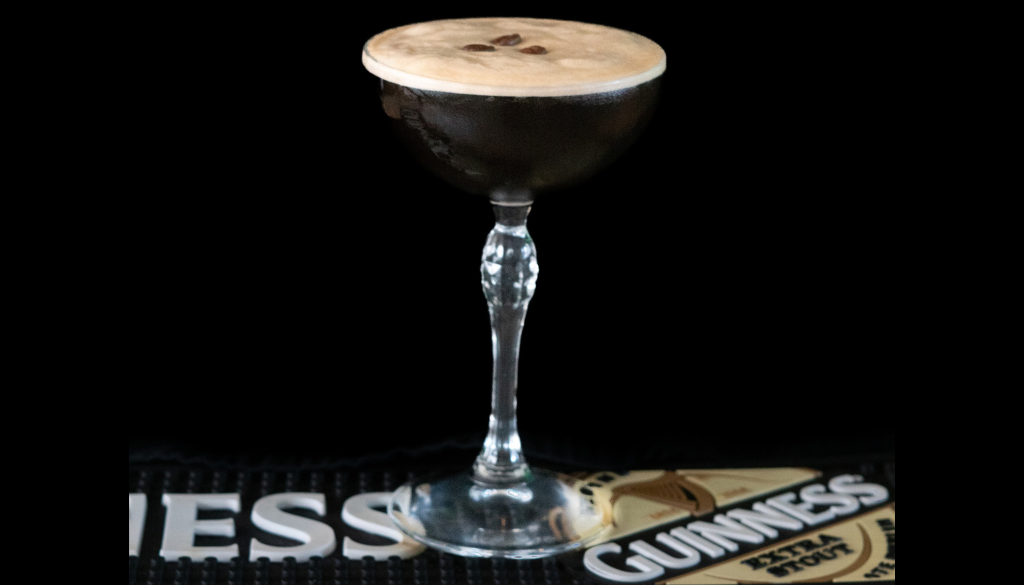 The Guinness Espresso Martini cocktail on a home bar top with an all black background