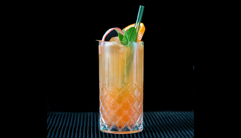The pot of gold mocktail on a home bar top with an all black background