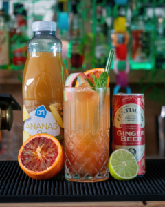The Pot of Gold mocktail on a home bar top surrounded with its ingredients
