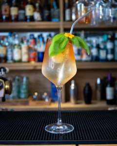 The Peach Spritz cocktail on a home bar top