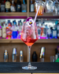 The Rhubarb & Hibiscus Spritz Mocktail on a home bar top