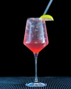 The Sarti Spritz cocktail on a home bar top with an all black background