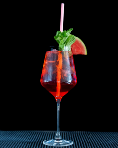 The Watermelon Spritz cocktail on a home bar top with an all black background