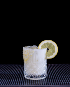 The Creamy Limoncello Margarita cocktail on a homebar top, with an all black background