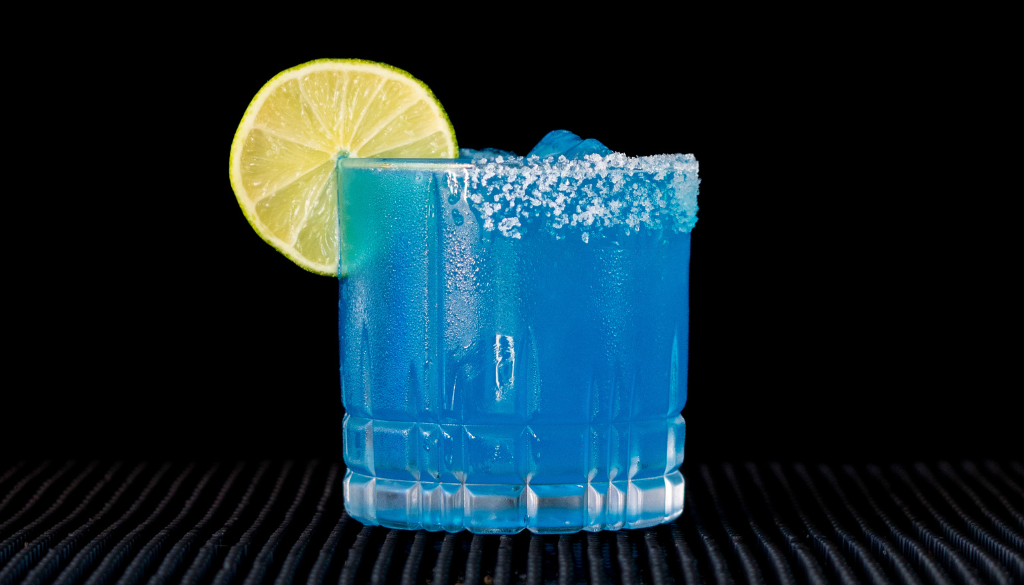 The Margarita Azul cocktail on a homebar top, with an all black background