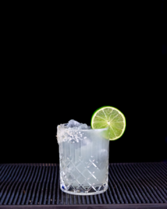 The Mezcal Margarita cocktail on a homebar top with an all black background