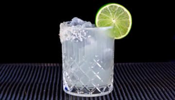The Mezcal Margarita cocktail on a homebar top with an all black background