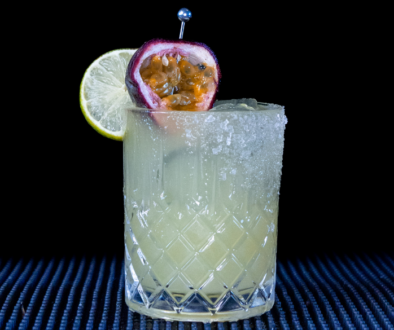 The Passionfruit Margarita cocktail on a home bar top with an all black background