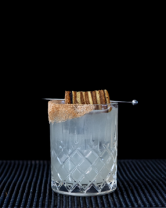 The Spekkoek Margarita cocktail on a homebar top, with an all black background