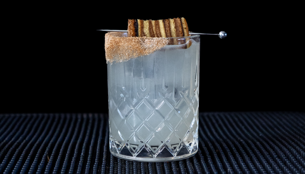 The Spekkoek Margarita cocktail on a homebar top, with an all black background