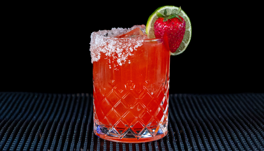 The Strawberry Margarita cocktail on a homebar top, with an all black background
