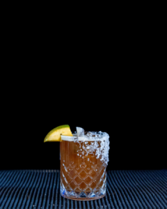 The Tropical Coffee Margarita cocktail on a home bar top with an all black background