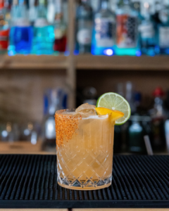 The Hot Honey Peach Margarita cocktail on a home bar top